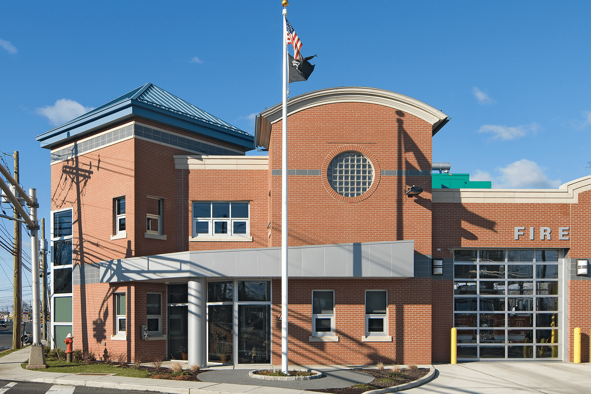 Brick exterior of Linden Fire Station No. 2, with its curved parapet, circular window, and entrance canopy.